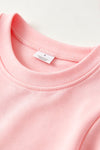 Lt. Pink Christmas character holding a bow and ruffle hem on sleeves. TPG60756 BRE