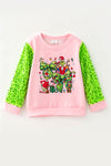 2 Bows & Christmas character printed on Lt. Pink top with green sequins sleeves. TPG60768 BRE
