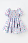 Blue gingham w/ pumpkin printed smocked tiered dress. DRG65299 SOL