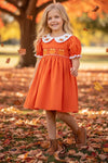 Orange smocked dress with embroidered pumpkin. DRG64521 AMY