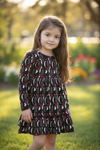 Black multi-printed girls dress with ruffle hem.