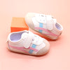 Off white infant tennis shoes with pink & blue design & velcro. YSA007P